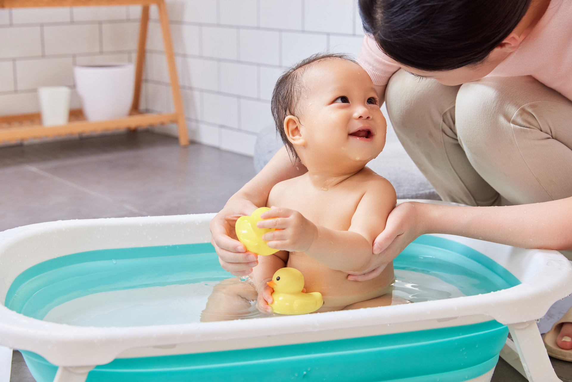 刚出生的女婴用充气游泳圈洗澡。照片摄影图片_ID:351986431-Veer图库